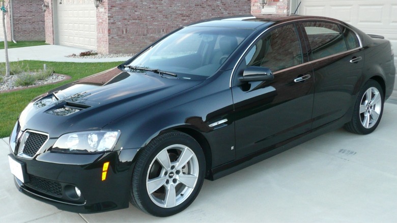 Black 2009 Pontiac G8 GT parked in front of a garage door on concrete driveway