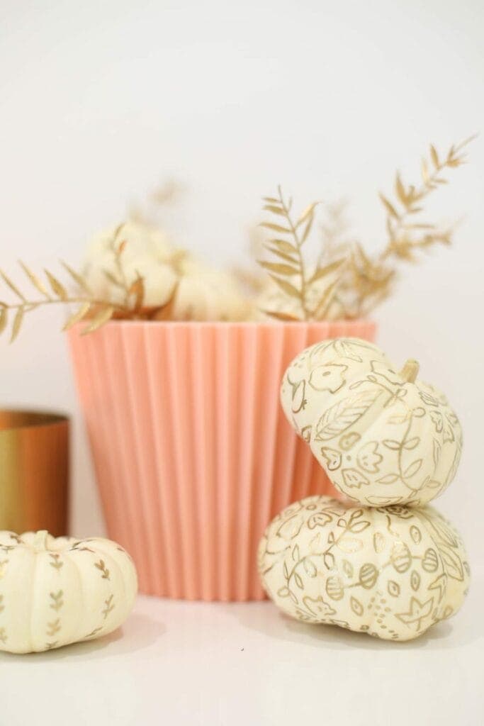 Painted pumpkins with a botanical gold pattern for fall