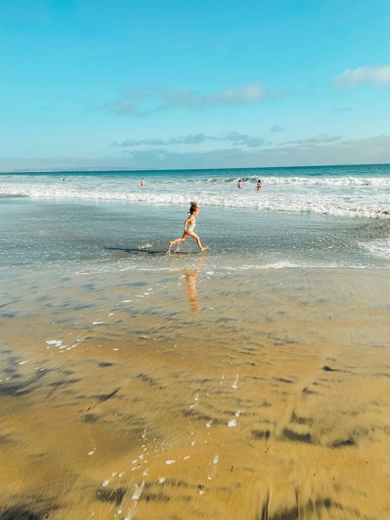 girl running on coronado beach in san diego